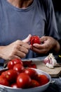 Young caucasian man peeling a scalded tomato Royalty Free Stock Photo