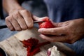 Young caucasian man peels a scalded tomato Royalty Free Stock Photo