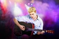 Young Caucasian man playing guitar in concert Royalty Free Stock Photo