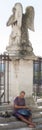 Young Caucasian man plays hang drum on the stairs to an angel statue in Avignon, France