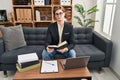 Young caucasian man psychologist reading book at psychology clinic Royalty Free Stock Photo