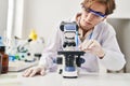 Young caucasian man scientist using microscope pouring liquid on sample at laboratory Royalty Free Stock Photo