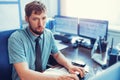 A young Caucasian man sits at his desk and types on a keyboard. A tired clerk or dispatcher looks at the monitor. Royalty Free Stock Photo