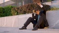 Young man sits on the pavement and strikes his briefcase after getting fired. Royalty Free Stock Photo