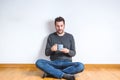 Young caucasian man sitting on the floor with a mug on his hands Royalty Free Stock Photo