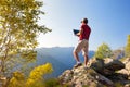 Young caucasian man sitting outdoor on a rock working on a laptop pc in mountain area. Royalty Free Stock Photo