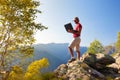 Young caucasian man sitting outdoor on a rock working on a laptop pc in mountain area. Royalty Free Stock Photo