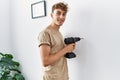 Young caucasian man smiling confident drilling wall at home Royalty Free Stock Photo