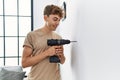 Young caucasian man smiling confident drilling wall at home Royalty Free Stock Photo