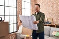 Young caucasian man smiling confident looking house plans at new home Royalty Free Stock Photo