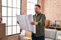 Young caucasian man smiling confident looking house plans at new home Royalty Free Stock Photo