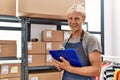 Young caucasian man smiling confident writing on clipboard at warehouse Royalty Free Stock Photo