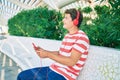 Young caucasian man smiling happy using touchpad and headphones sitting on the bench Royalty Free Stock Photo