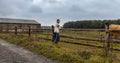 Young caucasian man standing on stackade farm in rural czech landscape