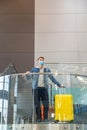 Young caucasian man with suitcase waiting at airport his departure. Man in protective face mask with luggage In airport Royalty Free Stock Photo