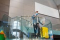Young caucasian man with suitcase waiting at airport in waiting room for his departure. Man in protective face mask with Royalty Free Stock Photo