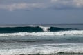 Young caucasian man surfs the ocean wave and makes a lot of splashes into the camera. Nyang Nyang Surf Spot in Bali, Indonesia. Royalty Free Stock Photo