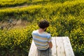 Young caucasian man taking a break surrounded by rapeseeds