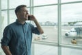 Young caucasian man talking on mobile phone at airport Royalty Free Stock Photo