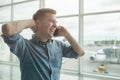 Young caucasian man talking on mobile phone at airport Royalty Free Stock Photo