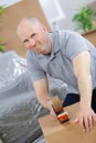 young caucasian man using duct tape for packing box Royalty Free Stock Photo