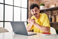 Young caucasian man using laptop drinking coffee at home Royalty Free Stock Photo