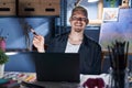 Young caucasian man using laptop at night at art studio with a big smile on face, pointing with hand and finger to the side Royalty Free Stock Photo