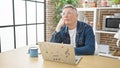 Young caucasian man using laptop thinking at dinning room Royalty Free Stock Photo