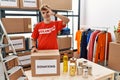 Young caucasian man volunteer holding donations box doing ok gesture with hand smiling, eye looking through fingers with happy Royalty Free Stock Photo