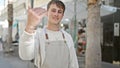 Young caucasian man waiter smiling confident doing come gesture at coffee shop terrace Royalty Free Stock Photo