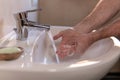 Young caucasian man washing hands rubbing with soap under running water tap in bathroom. Personal hygiene and healthcare Royalty Free Stock Photo