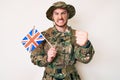 Young caucasian man wearing camouflage army uniform holding united kingdom flag annoyed and frustrated shouting with anger, Royalty Free Stock Photo