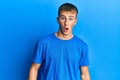 Young caucasian man wearing casual blue t shirt afraid and shocked with surprise and amazed expression, fear and excited face Royalty Free Stock Photo