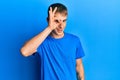 Young caucasian man wearing casual blue t shirt doing ok gesture with hand smiling, eye looking through fingers with happy face Royalty Free Stock Photo