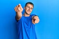 Young caucasian man wearing casual blue t shirt pointing to you and the camera with fingers, smiling positive and cheerful Royalty Free Stock Photo