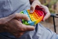 Man pops bubbles of a colorful destressing toy Royalty Free Stock Photo