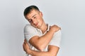 Young caucasian man wearing casual white polo hugging oneself happy and positive, smiling confident Royalty Free Stock Photo