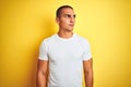 Young caucasian man wearing casual white t-shirt over yellow isolated background smiling looking to the side and staring away Royalty Free Stock Photo