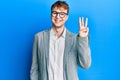 Young caucasian man wearing elegant clothes and glasses showing and pointing up with fingers number three while smiling confident Royalty Free Stock Photo