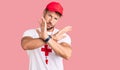 Young caucasian man wearing lifeguard t shirt holding whistle rejection expression crossing arms doing negative sign, angry face