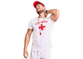 Young caucasian man wearing lifeguard t shirt holding whistle suffering of neck ache injury, touching neck with hand, muscular