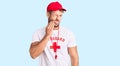 Young caucasian man wearing lifeguard t shirt holding whistle touching mouth with hand with painful expression because of