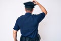 Young caucasian man wearing police uniform backwards thinking about doubt with hand on head