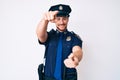 Young caucasian man wearing police uniform pointing to you and the camera with fingers, smiling positive and cheerful