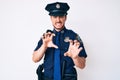 Young caucasian man wearing police uniform smiling funny doing claw gesture as cat, aggressive and sexy expression Royalty Free Stock Photo