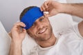 Young caucasian man wearing sleepmask lying on bed at bedroom