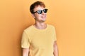 Young caucasian man wearing stylish sunglasses looking to side, relax profile pose with natural face and confident smile Royalty Free Stock Photo