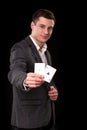 Young caucasian man wearing suit holding two aces in his hand on black background. Gambling concept. Casino Royalty Free Stock Photo