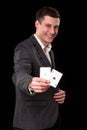 Young caucasian man wearing suit holding two aces in his hand on black background. Gambling concept. Casino Royalty Free Stock Photo