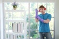 Young Caucasian man Wearing violet rubber gloves for clean of housework and relaxing for listening to music with red headphone. Royalty Free Stock Photo